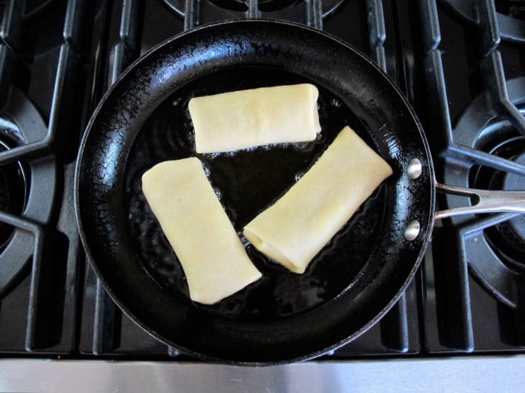 Frying blintzes in a skillet.