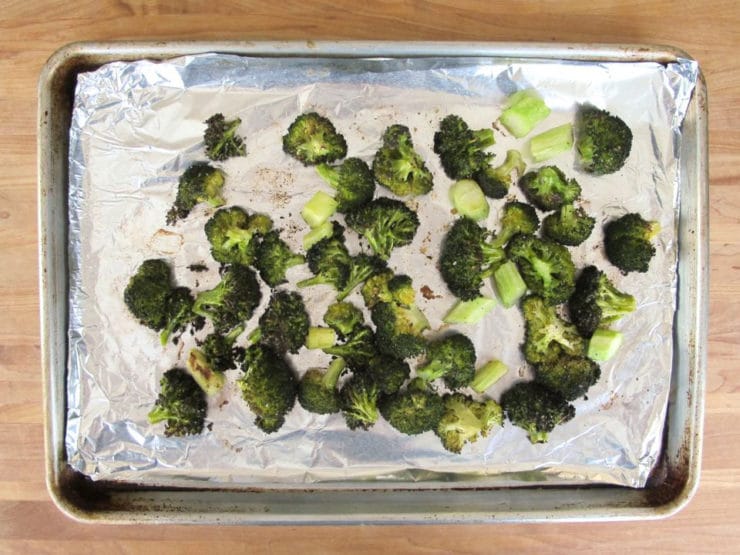 Roasted broccoli on a baking sheet.