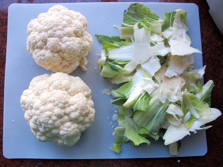 Stem and leaves removed from cauliflower heads.