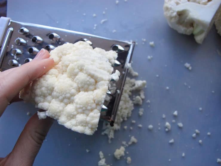 Grating a head of cauliflower.