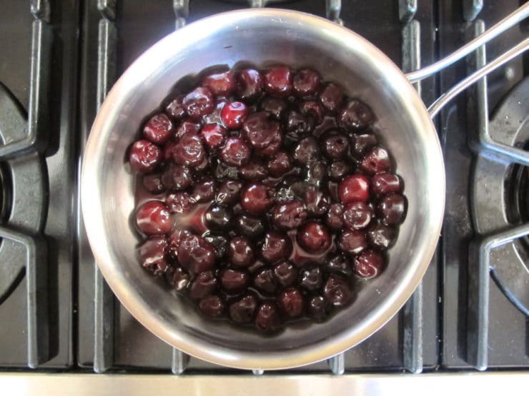 Heating cherries and coffee in a saucepan.
