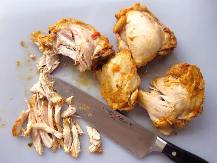 Slicing chicken thighs.