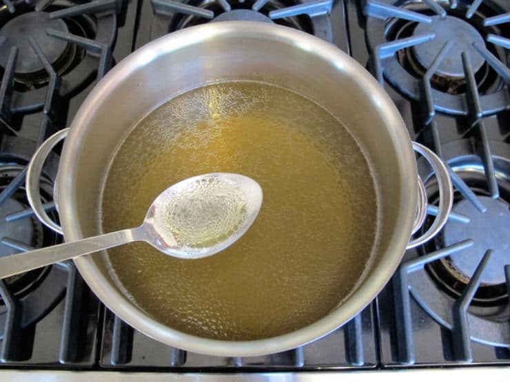 Skimming fat from chicken broth.