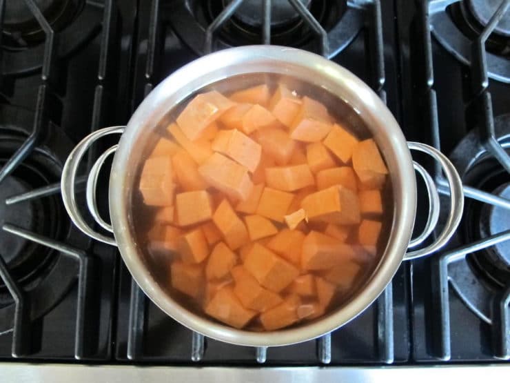 Cut sweet potatoes boiling in a stockpot.