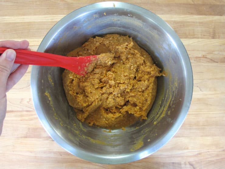 Beating butter and sugar into mashed sweet potatoes.