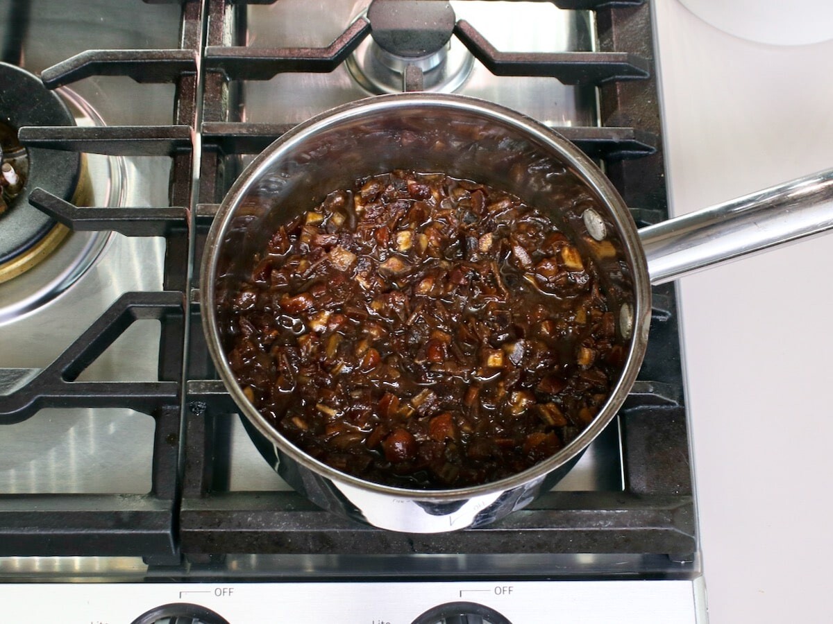 Saucepan filled with bubbling date filling on the stovetop.