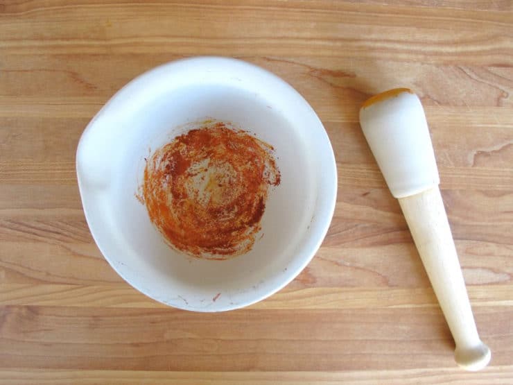 Grinding saffron with a mortar and pestle.