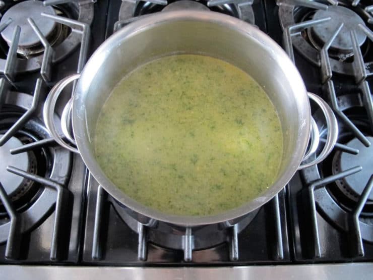 Tahini stirred into soup in stockpot.