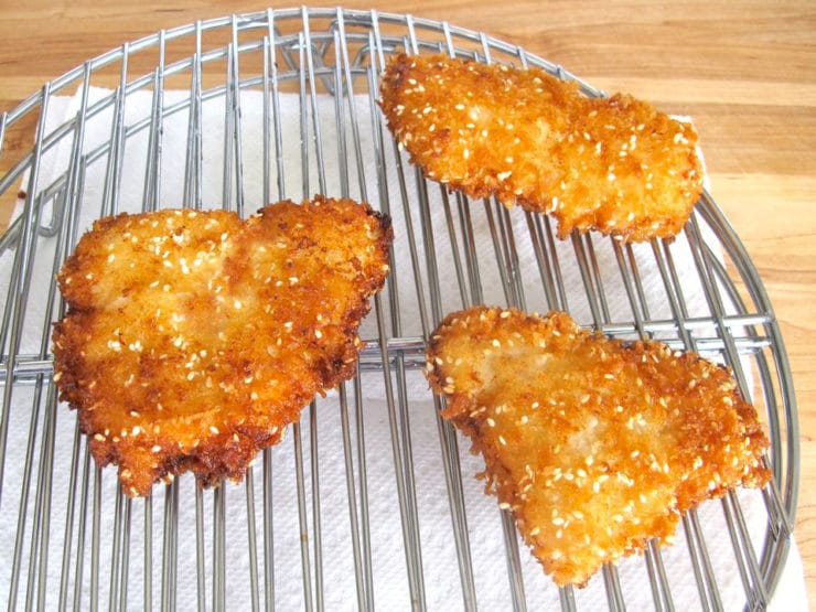 Fried fish fillets draining on a rack.