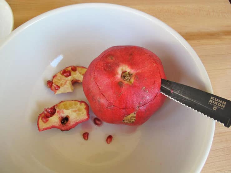 Slice the bottom off a pomegranate.