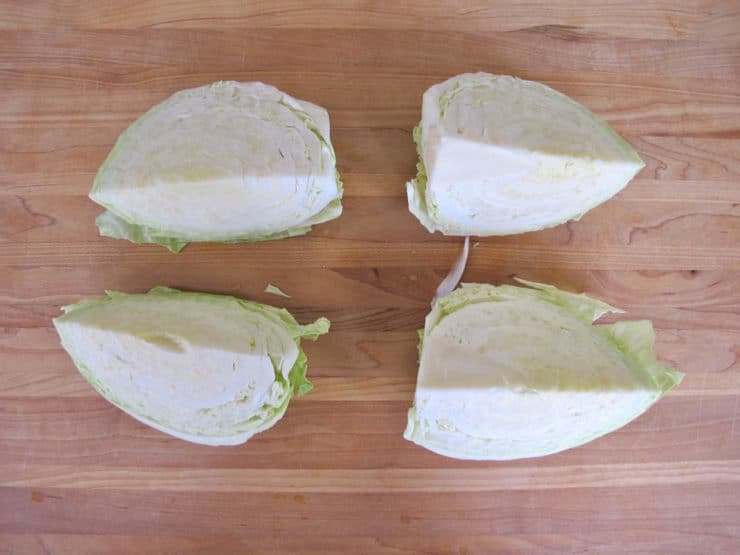 Close-up of cabbage cut into 4 pieces with vibrant green leaves