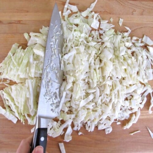 Chopped cabbage being prepared on cutting board
