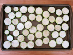 Sliced zucchini on a baking tray.