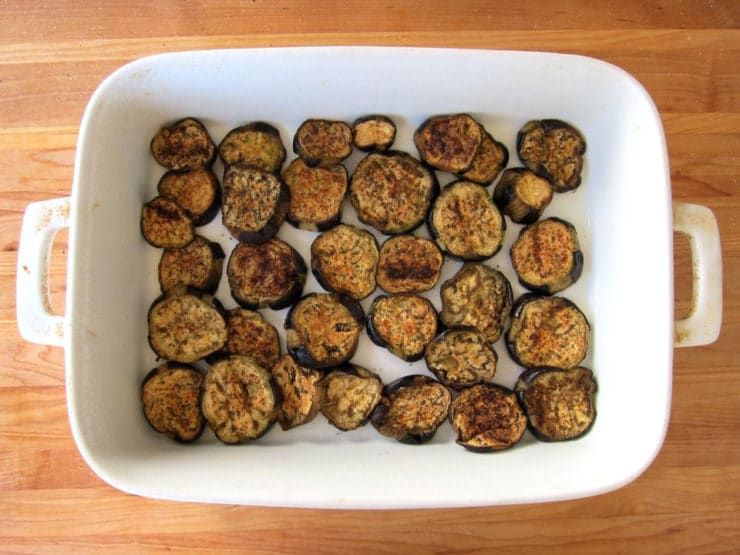 Roasted eggplant layered in a baking dish.