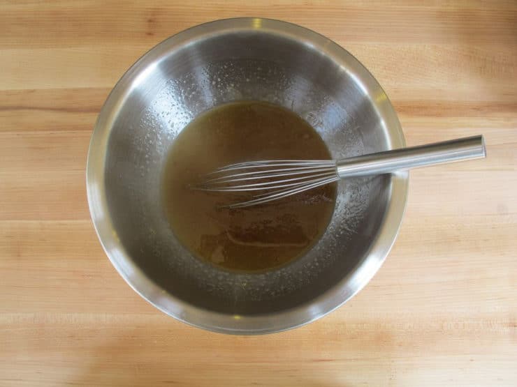 Whisking oil, sugar, and eggs in a mixing bowl.