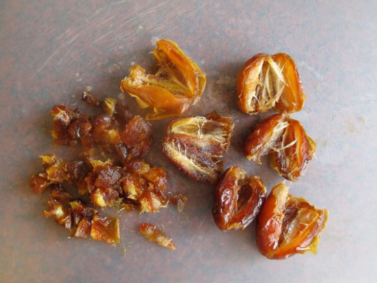 Chopping dates on a cutting board.