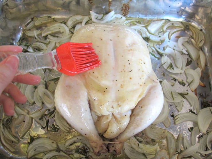 Basting whole chicken.
