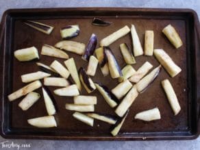 Roasting eggplant slices on baking sheet to make mnazaleh, a traditional Middle Eastern Druze recipe.