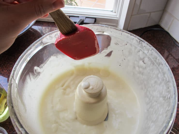 Scraping sides of food processor.