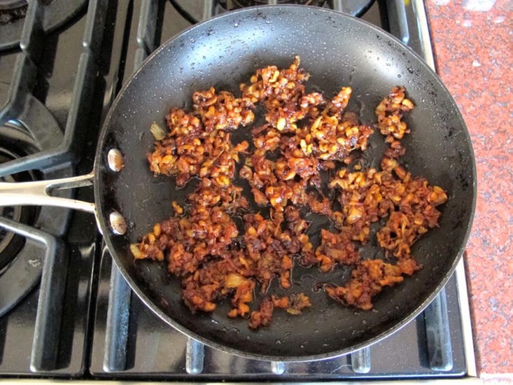 Chicken skin and onions in a skillet.