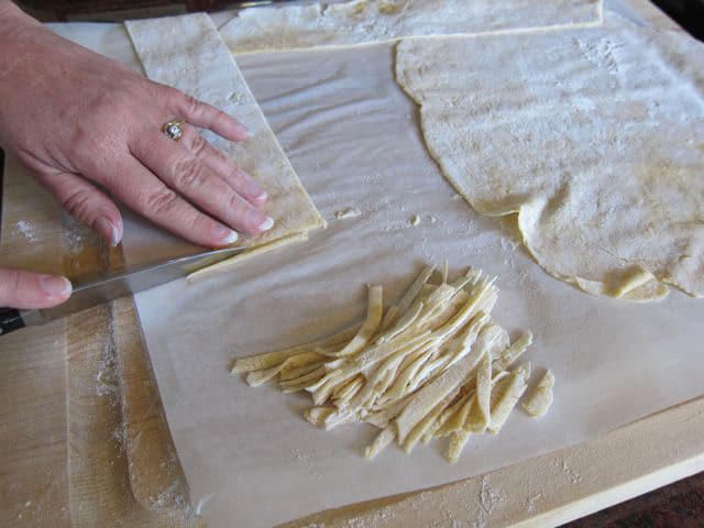 Cutting dried dough into strips.