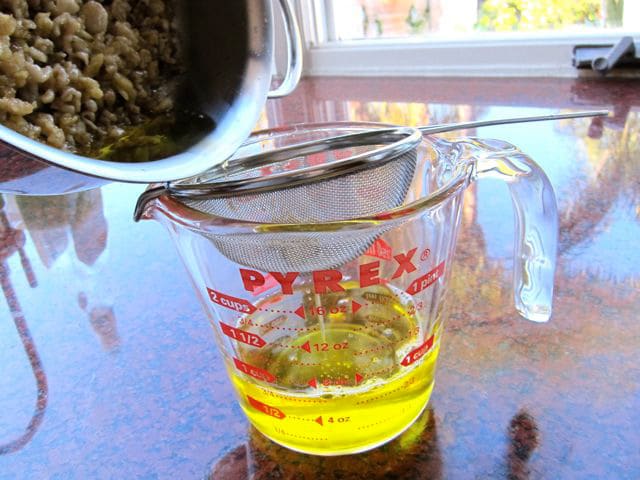 Straining chicken fat from the skin.