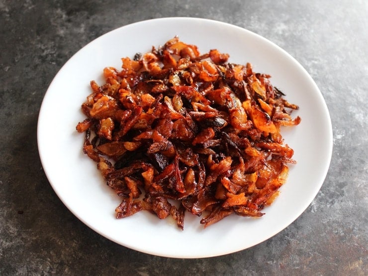 Crispy gribenes on a plate on concrete background.