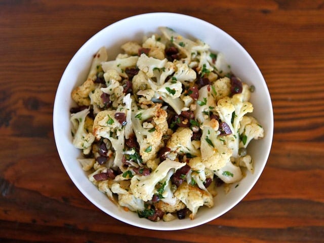 Horizontal cut - of Italian Roasted Cauliflower Salad serve on a white bowl.