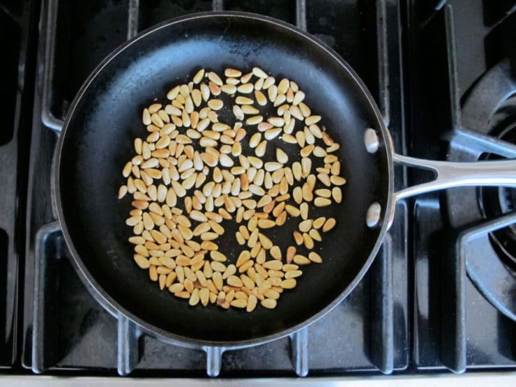 Dry toasting pine nuts in a skillet.