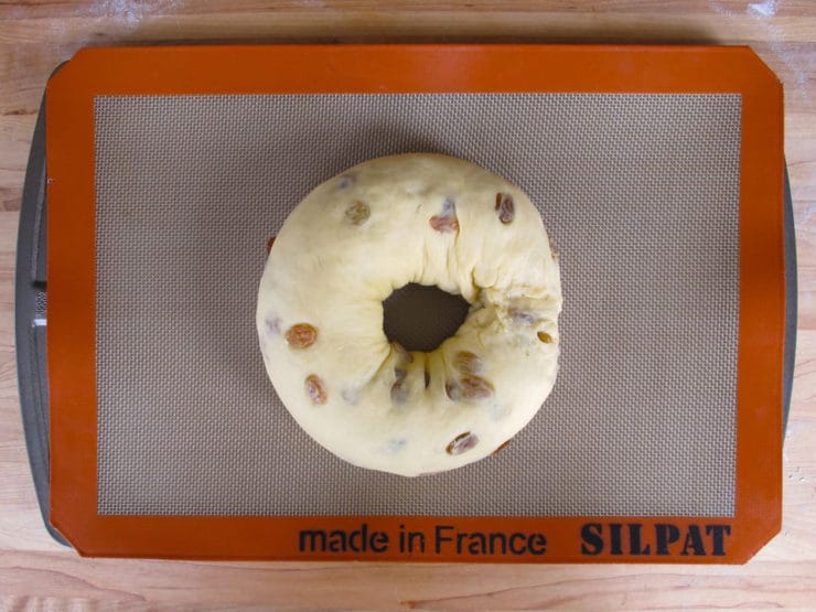 Bread dough ring on a lined baking sheet.