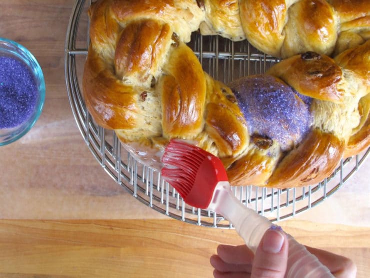 Spreading icing over braided loaf.