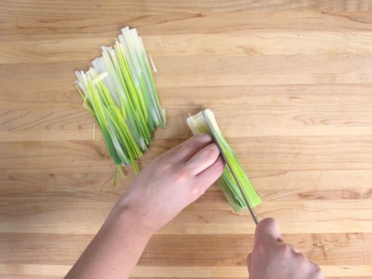 Slicing leeks into thin strips.
