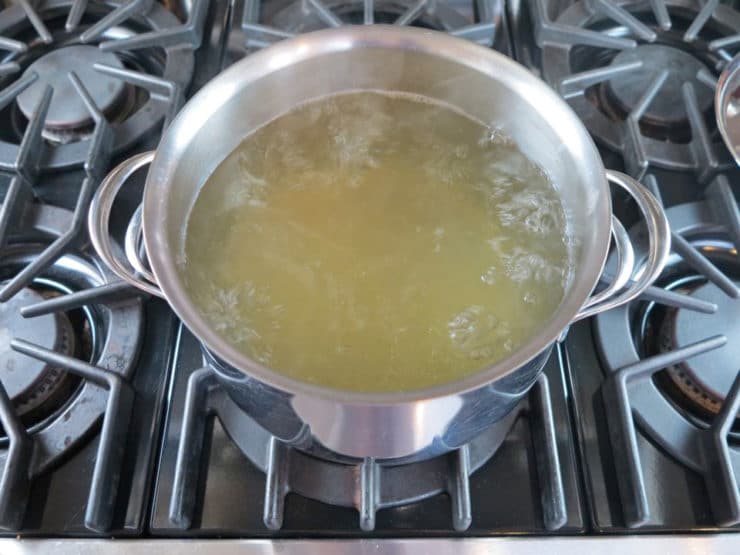Stockpot of boiling chicken stock.