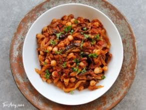 Chicken and chickpea stew with tomatoes and Mnazeleh - a hearty and flavorful dish served on a big white plate