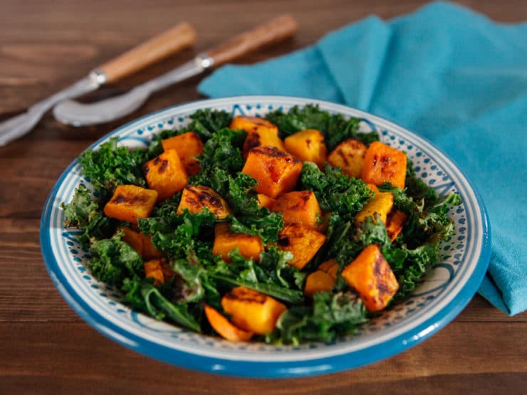 Slant image of delicious and nutritious dish featuring roasted butternut squash and crispy kale.