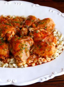 Michael Berkowits' Kosher Chicken Paprikash served on a fancy white plate and topped with finely chopped herbs