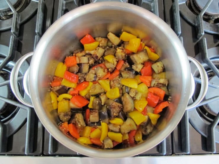 Peppers added to eggplant in stockpot.