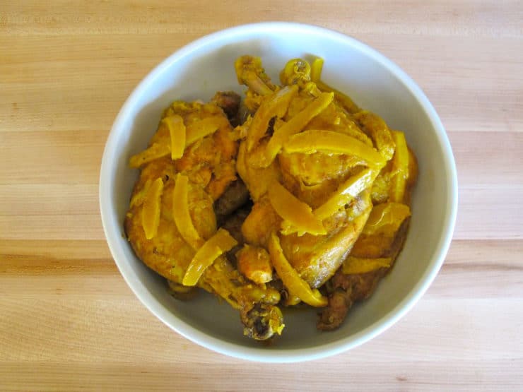 Cooked chicken quarters in a serving bowl.