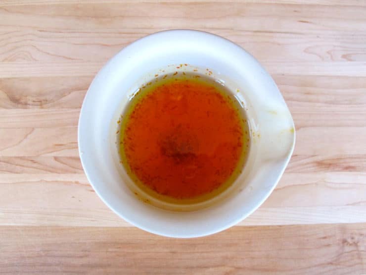 Saffron soaking in a bowl of oil and water.