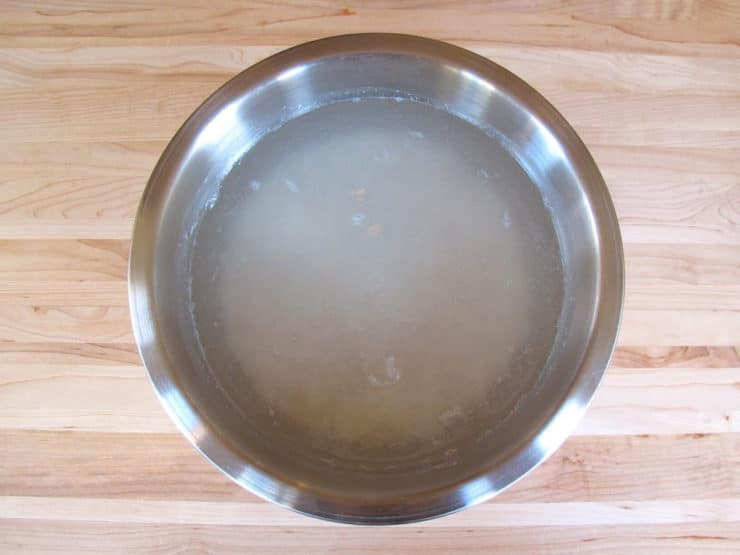 White rice soaking in a bowl of water.