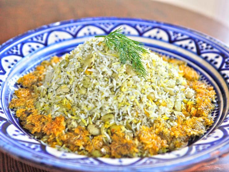 A close-up of Persian dill and lima bean rice on a patterned blue plate.
