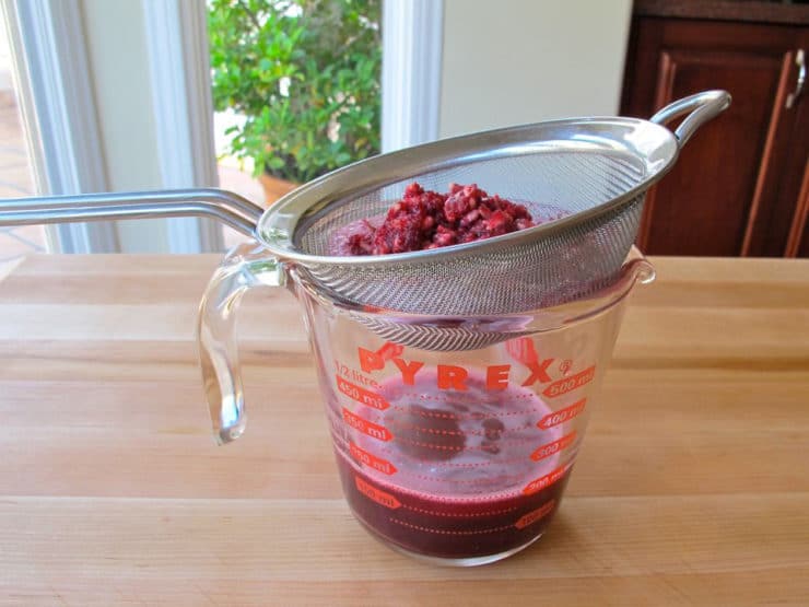 Straining pomegranate juice.