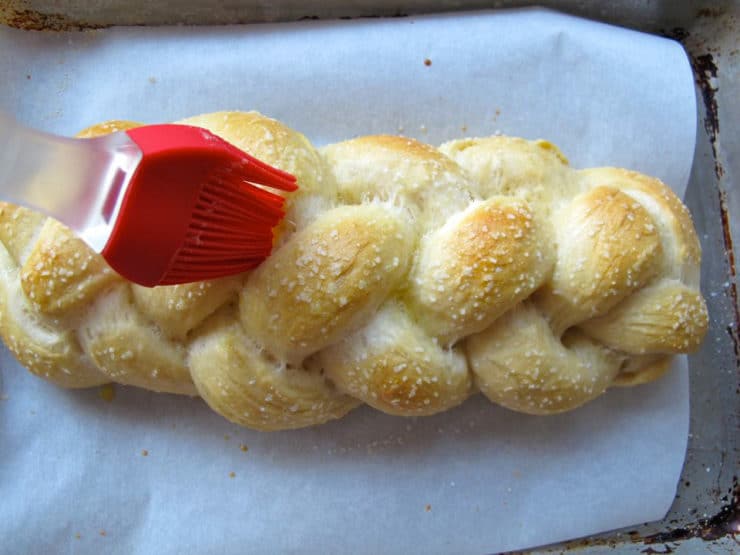 Brushing eggwash on half-baked challah.