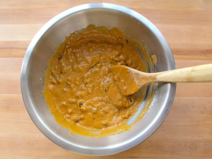 Raisins folded into cake batter in a bowl.