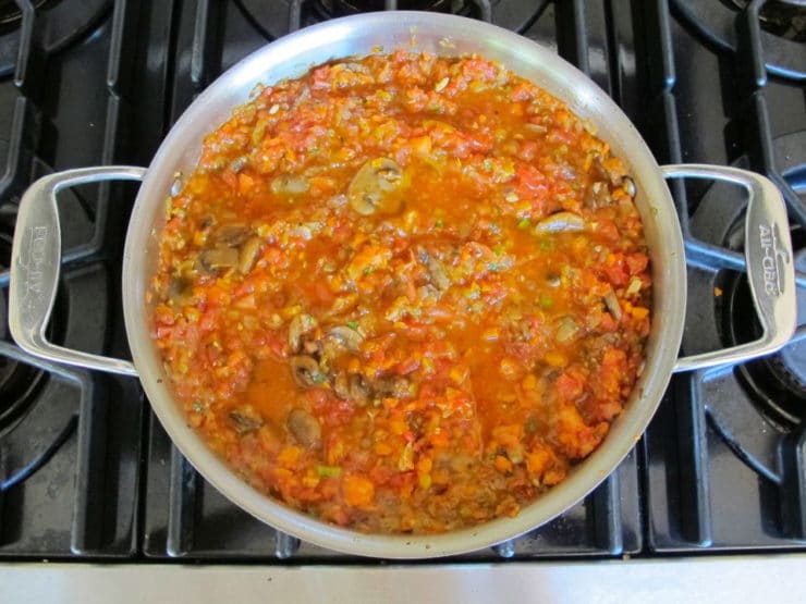 Mushrooms and tomatoes in a saucepan.