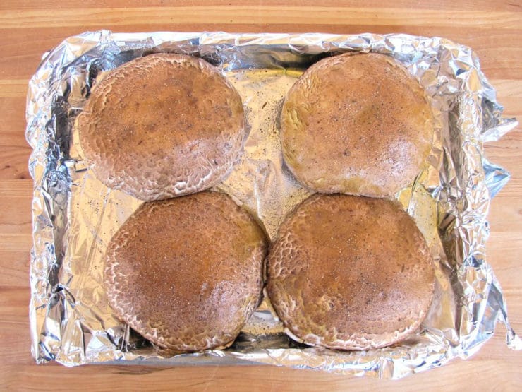 Mushroom caps on a foil-lined baking sheet.