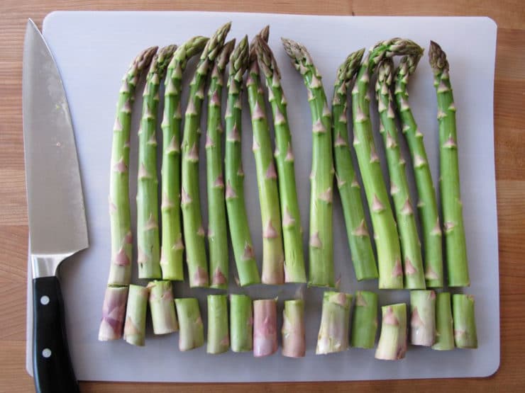Trimming the bottom end off asparagus.
