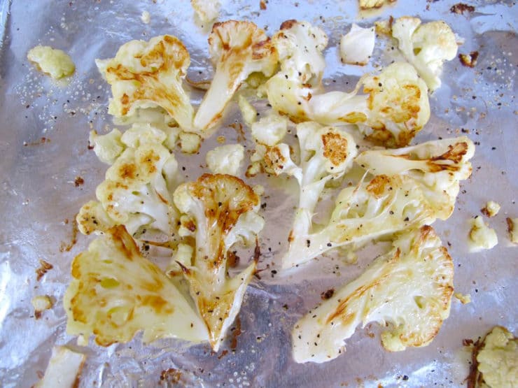 Caramelized roasted cauliflower florets on baking sheet.