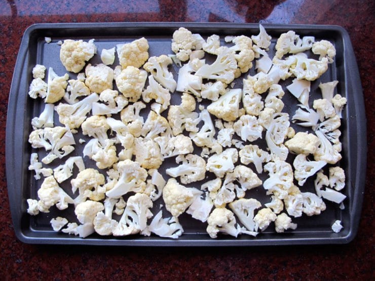 Cauliflower florets on a baking sheet.