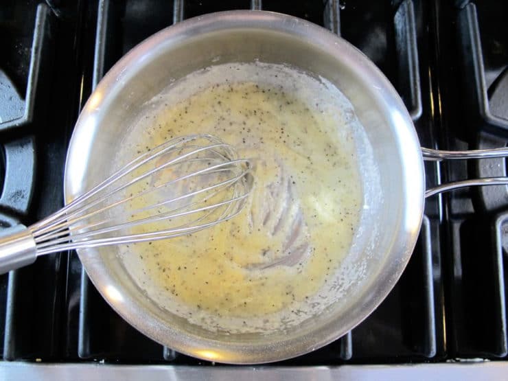 Whisking milk into a roux.